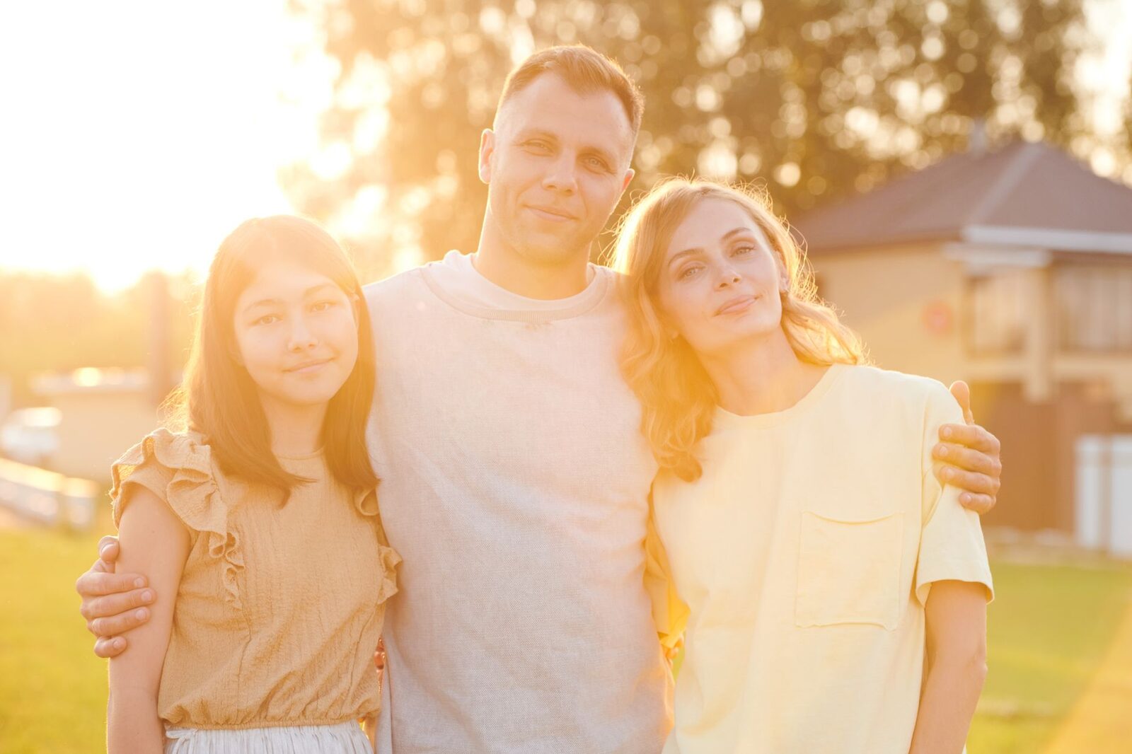 A cheerful family of three enjoying a sunny outdoor moment. Perfect for lifestyle and family content.